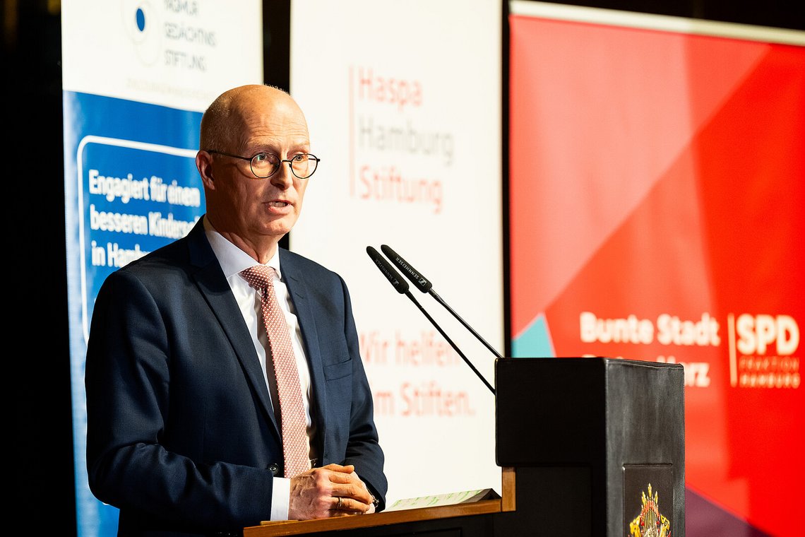 Dr. Peter Tschentscher spricht am Rednerpult vor Bannern der Yagmur-Gedächtnis-Stiftung