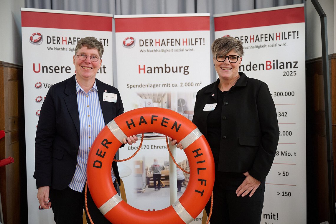 Zwei Vertreterinnen des Projekts „Der Hafen hilft!“ mit einem Rettungsring vor den Projekt-Rollups – Stiftungstreffen 2025