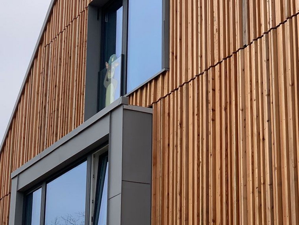 Moderne Holzfassade eines Gebäudes mit großen Fenstern