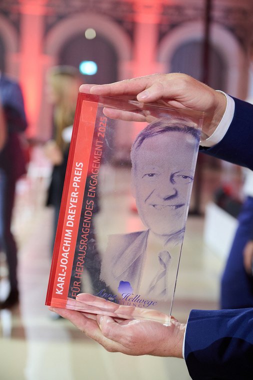 Gläserne Auszeichnung „Karl-Joachim-Dreyer-Preis für herausragendes Engagement 2025“ wird in den Händen gehalten – Stiftungstreffen 2025