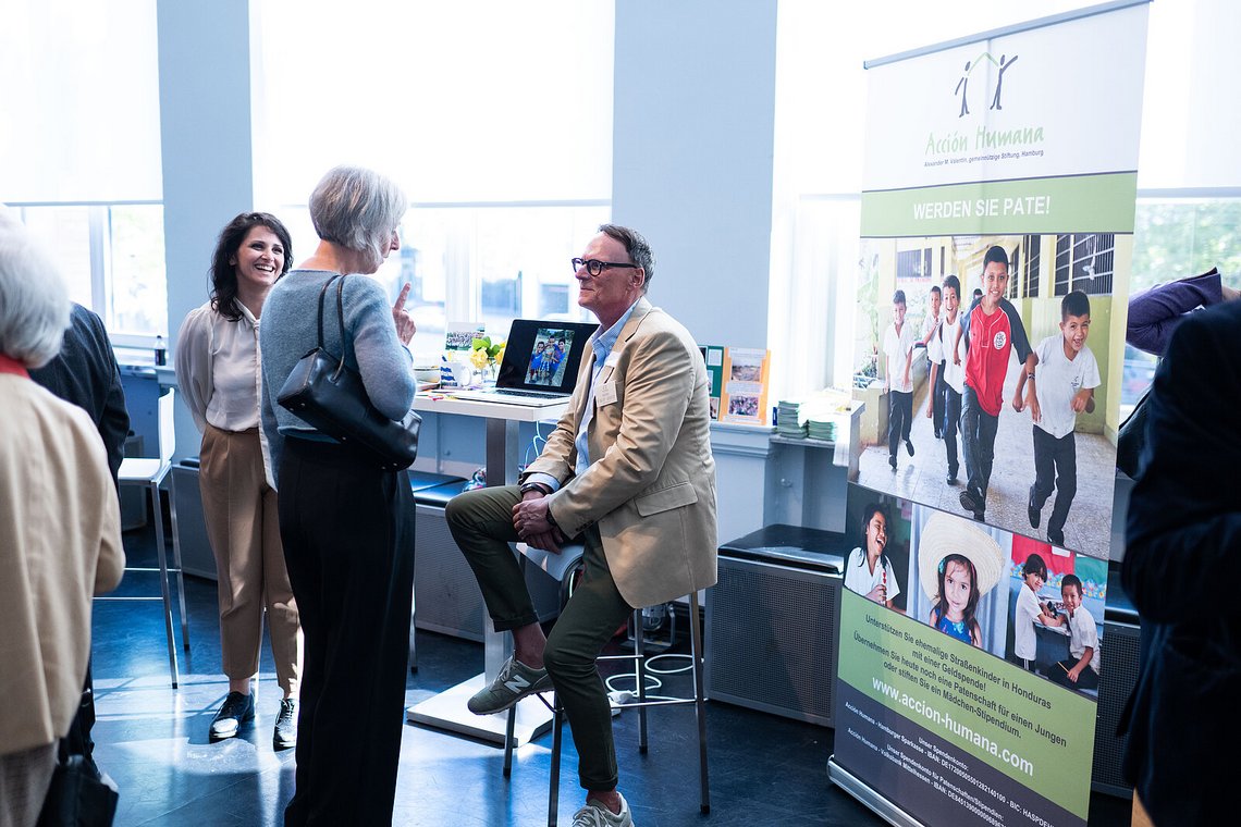 Gäste im Gespräch am Infostand der Stiftung „Acción Humana“ – Stiftungstreffen 2023